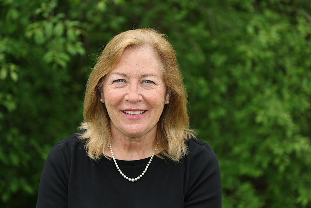 Cindy Steffen in front of a background of green leaves