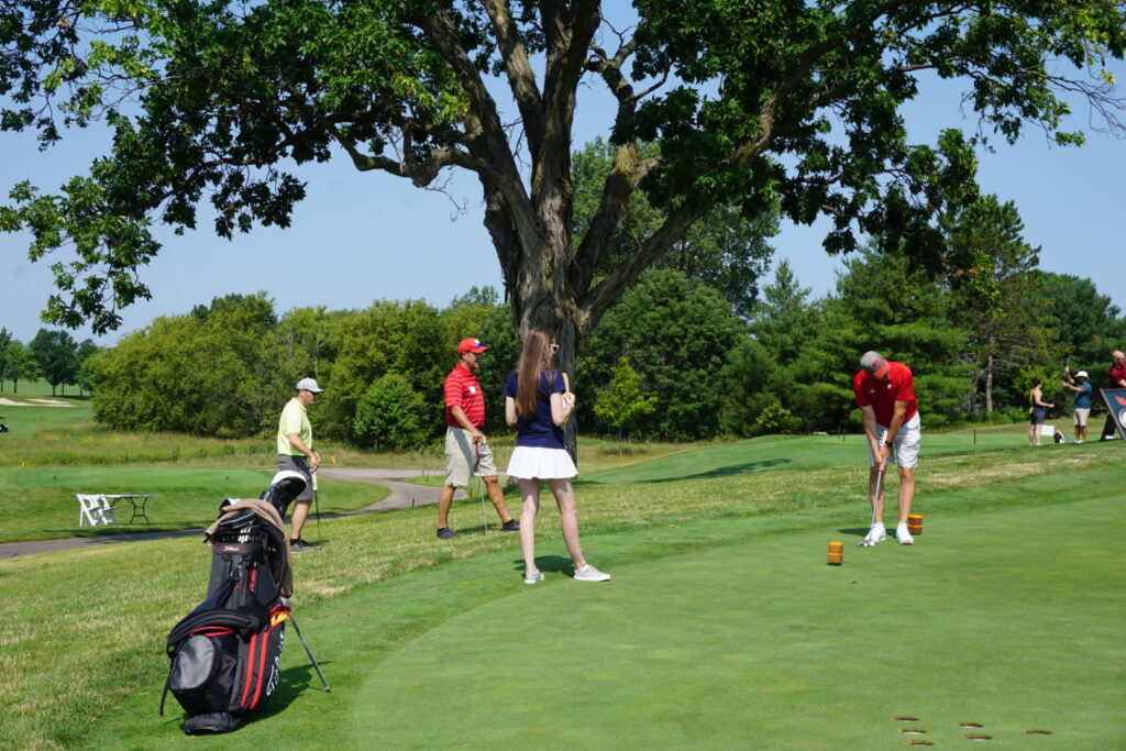 DSC07278 A badger alum getting ready to swing his golf club while others watch