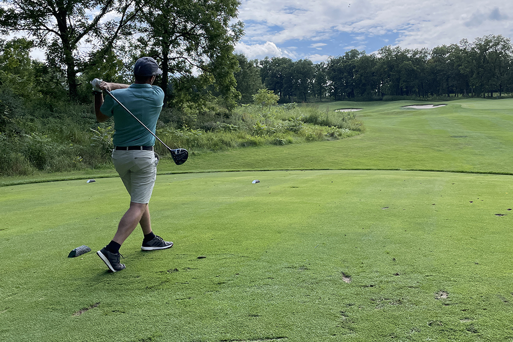 EF59A492-5514-4CF8-BB6B-E0DFD8ABC6A5 An alum taking a swing on the green.