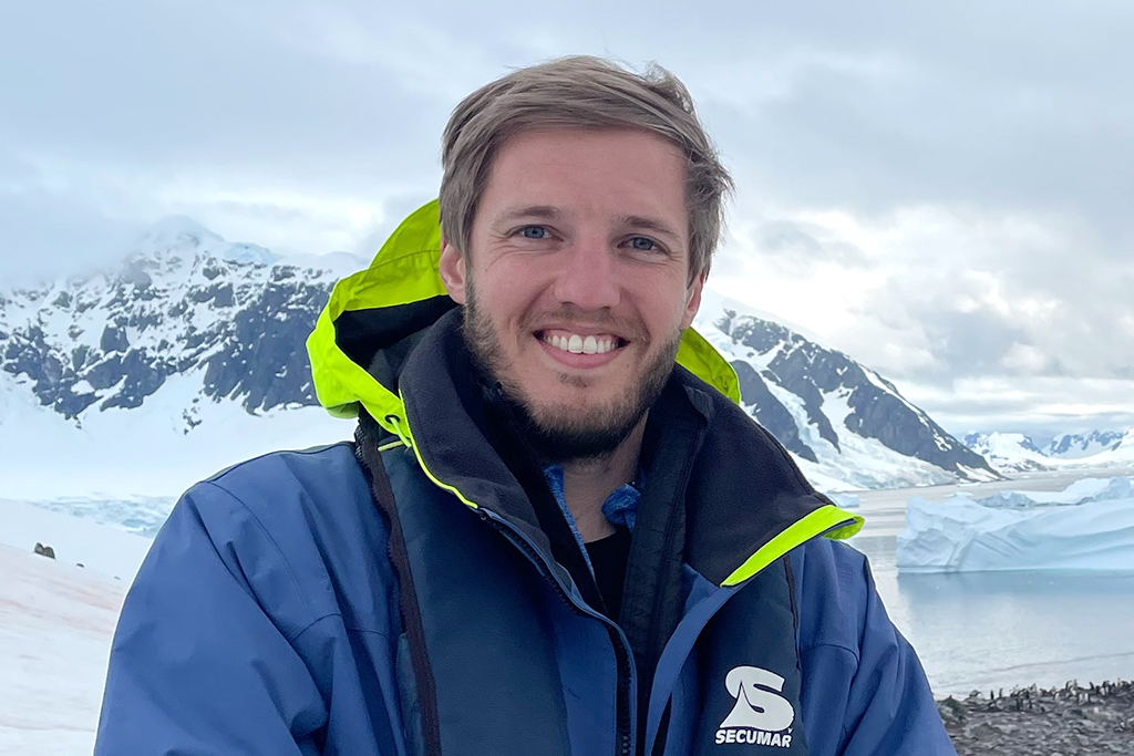 Greg Sitter in a winter jacket in front of a mountain