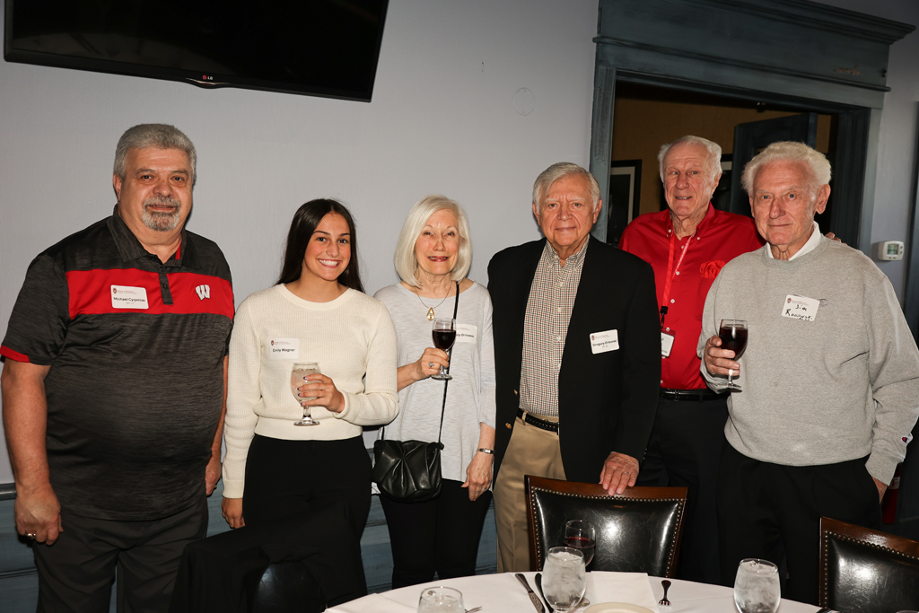 A group of alumni smile for a photo