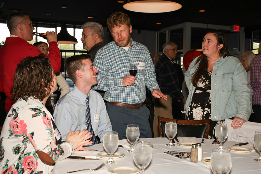 A group of alumni, including Jesse Schaetzel, speak at a table