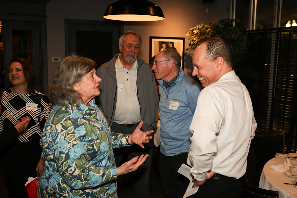 A group of attendees smile and laugh