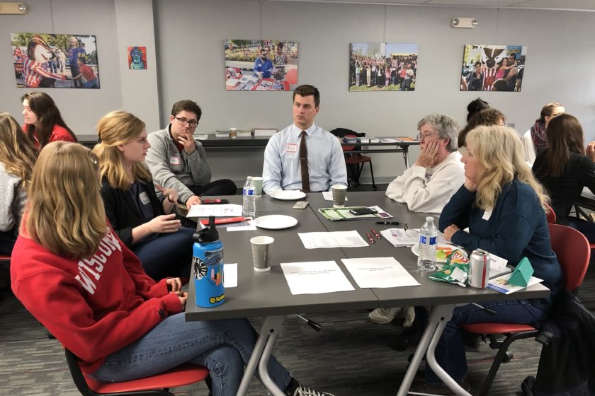 Students and attendees gathered around tables for Caring for the Caregiver event