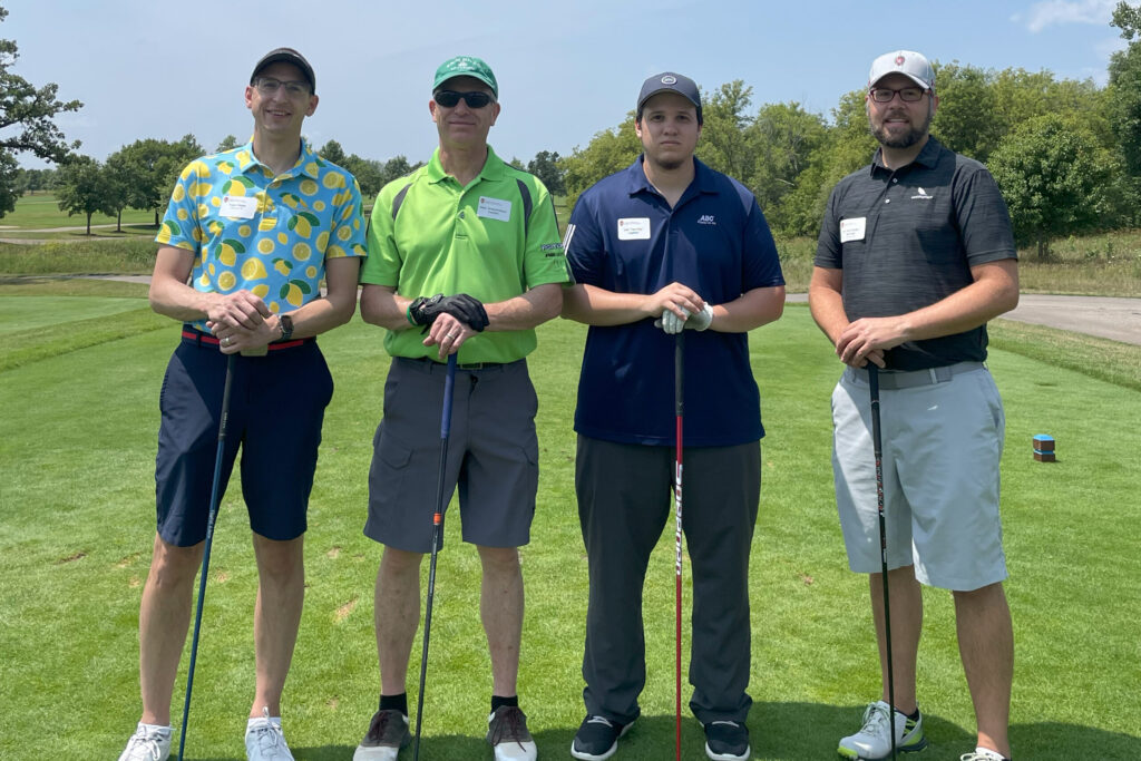 IMG_4316 Alumni taking a group picture together at a golf course