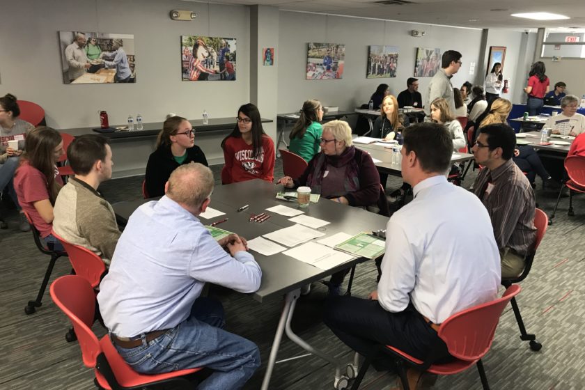 Students and attendees gathered around tables for Caring for the Caregiver event