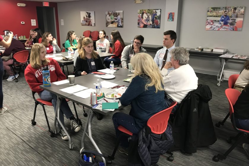 Students and attendees gathered around tables for Caring for the Caregiver event