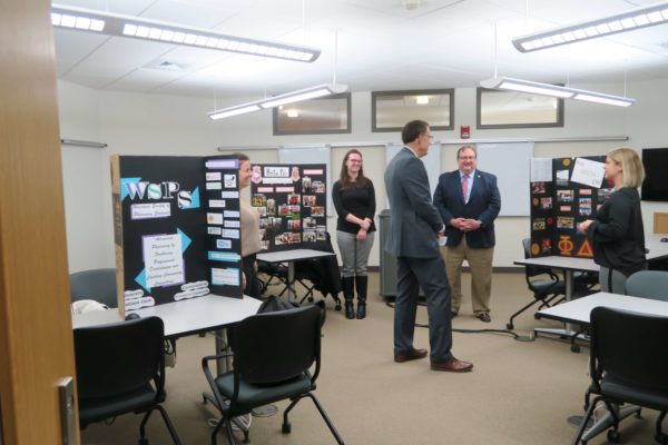 IMG_8707a Provost Karl Scholz standing in the middle of a room with different informational boards about student organizations with student leaders nearby