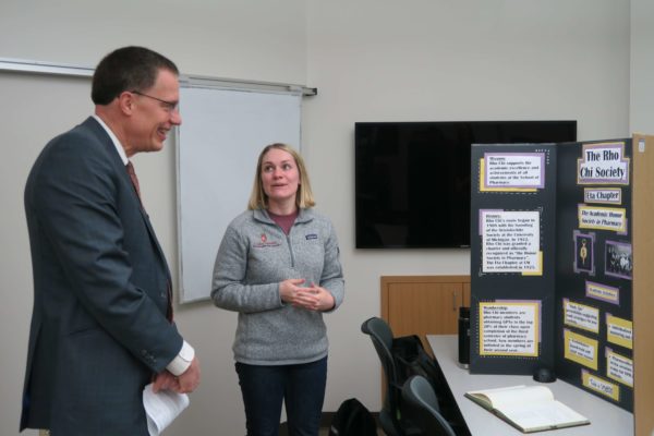 IMG_8708 Samantha Lewiston explaining her informational board about the Rho Chi Society to Provost Karl Scholz