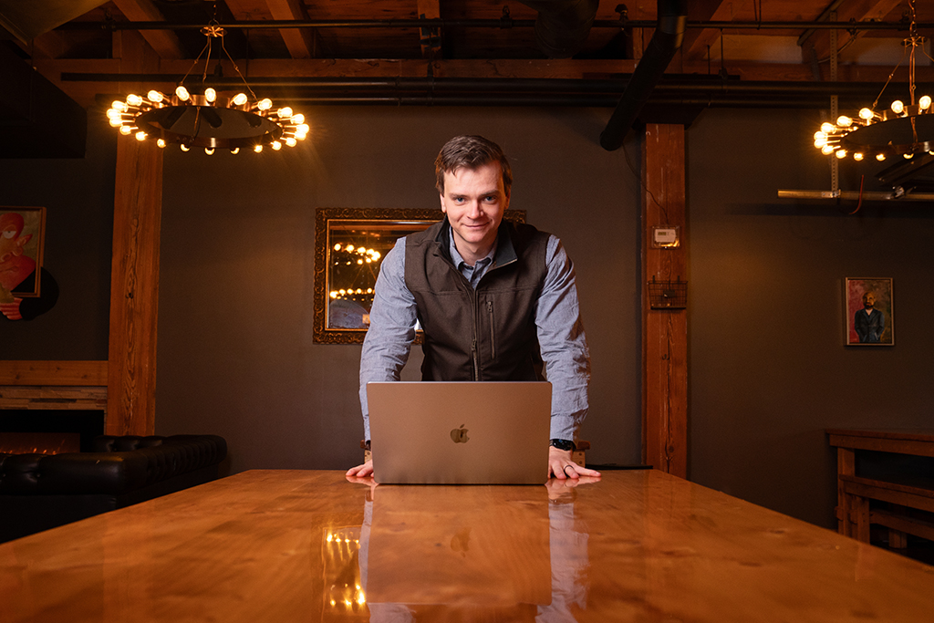 Ian Miller stands by his laptop