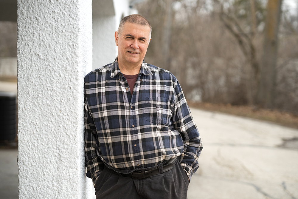 Mark Putzi leans on a post