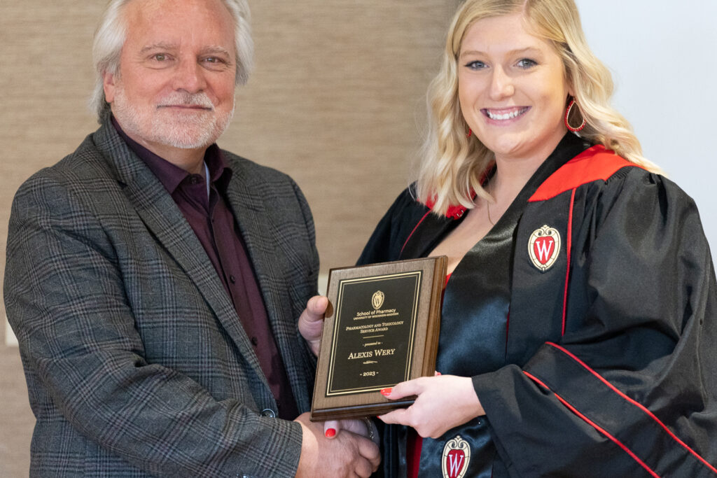 Alexis Wery poses with an award and Jeff Johnson.