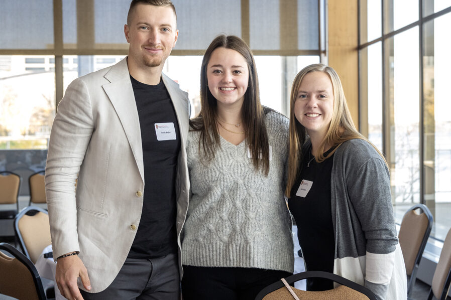 Denis Boyko, Gianna Santoro, and Leah Lofquist arm-in-arm facing camera