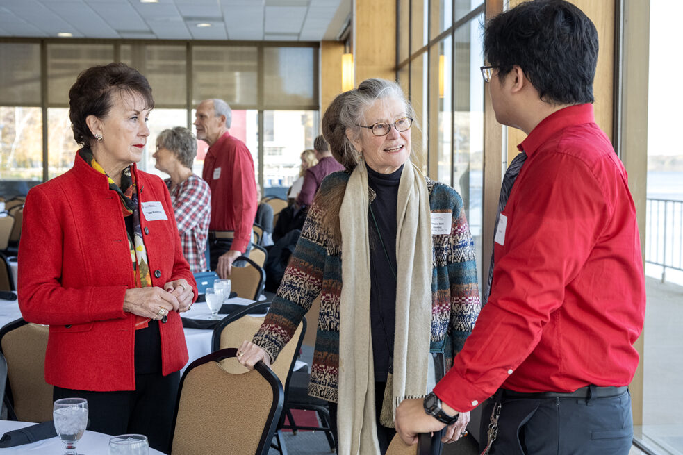Betty Chewning speaking to Steven Do with Peggy Wiederholt listening attentively