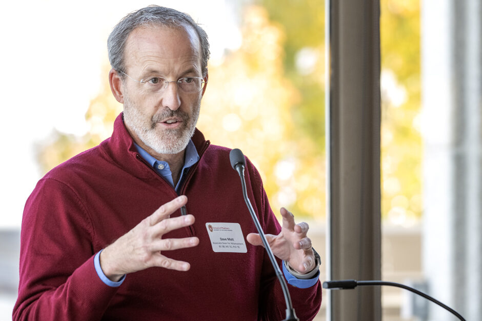 Dave Mott gesturing with his hands while speaking into microphone at podium