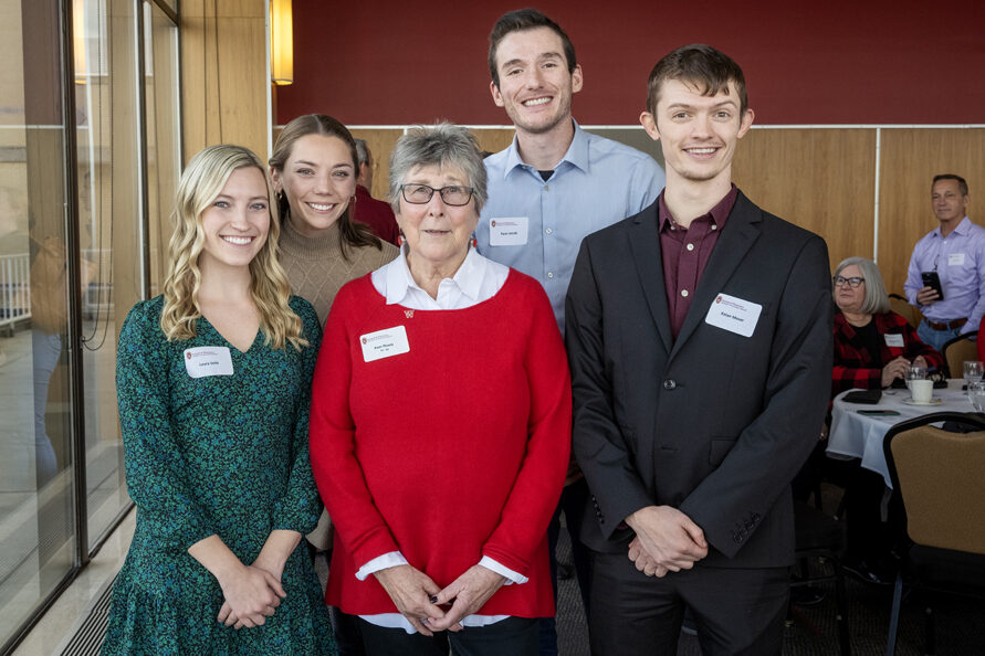 Pam Ploetz standing with PharmD students on each side of her