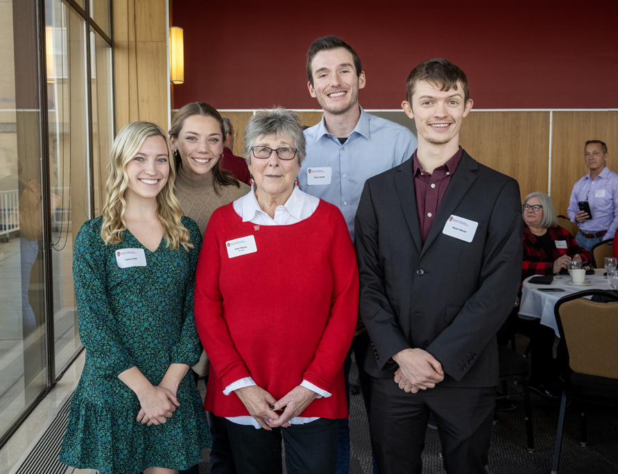 Pam Ploetz standing with PharmD students on each side of her