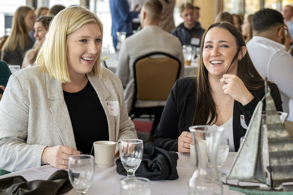Alexis Wery and Haley Smith smiling and talking while seated at table