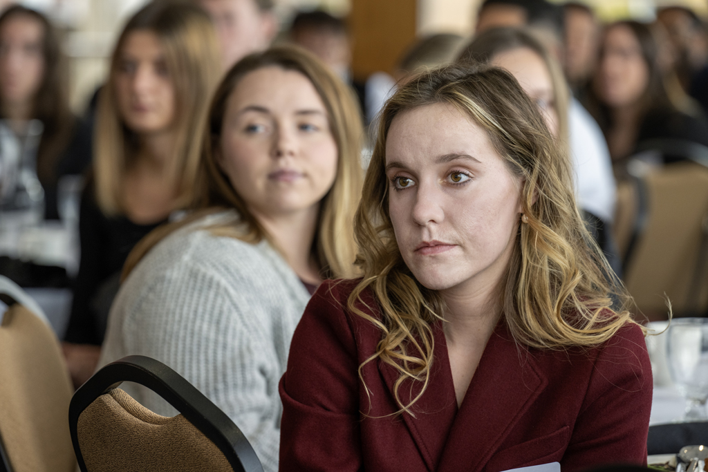 Camera focused on Alissa Cassady listening to speaker with her surroundings blurred