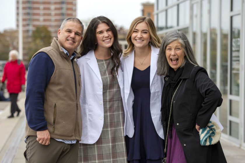 Students in white coats with their family after white coat ceremony