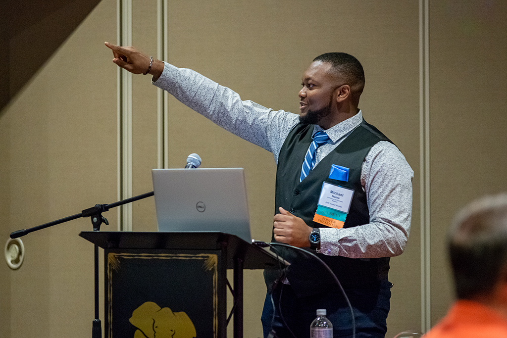 Pharmacy-Wis-Dells_020 PharmD student Michael Nome speaks at a podium, pointing toward the back of the room
