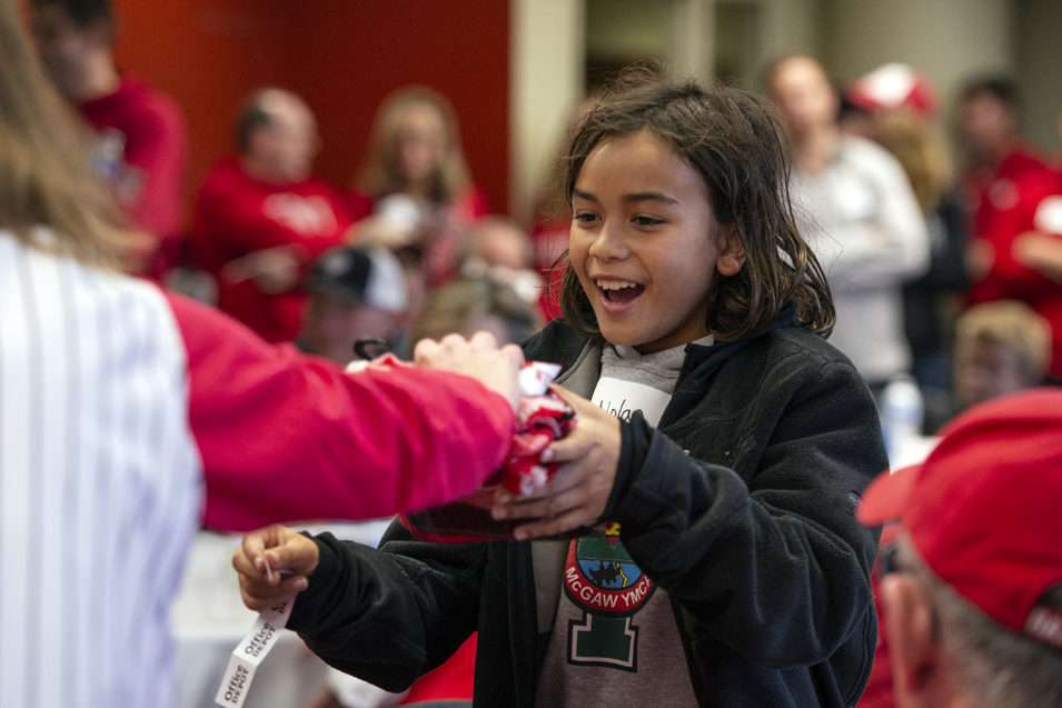 PharmacyAlumniTailgateEvent_1018_DSC_7203 A young child accepting a raffle prize at the UW-Madison Pharmacy Alumni Tailgate event, held at Union South during the Badgers vs. Cornhuskers game.