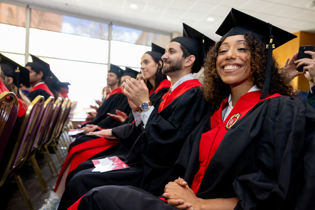 Pharmacy_Graduation_2024_047 Graduates listen to speakers and clap