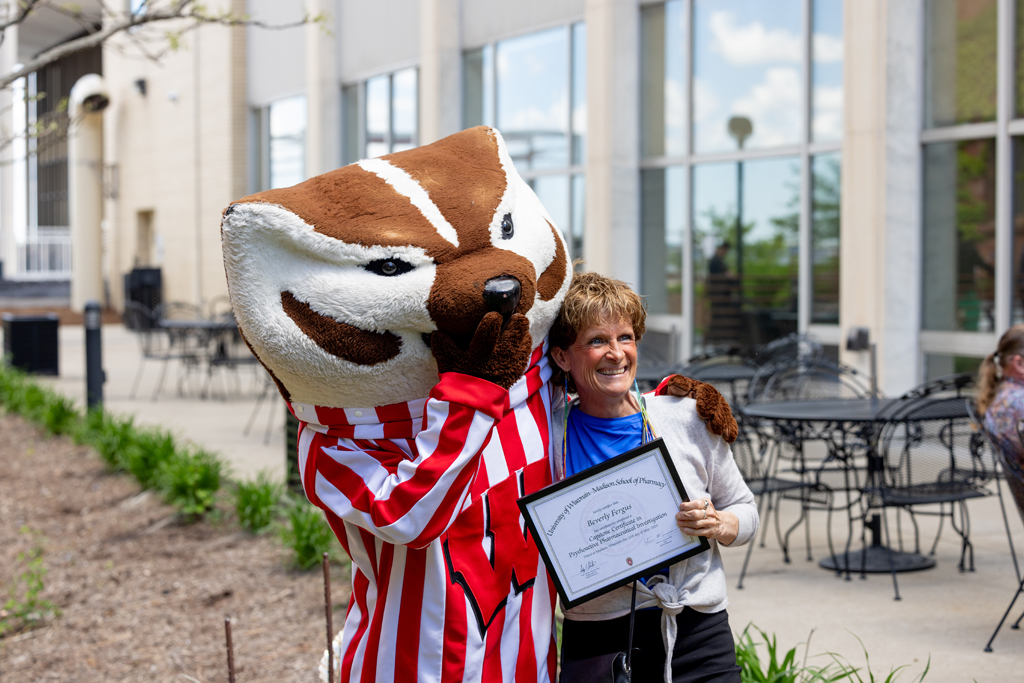 Pharmacy_Graduation_2024_151 A graduate's family member poses with Bucky Badger