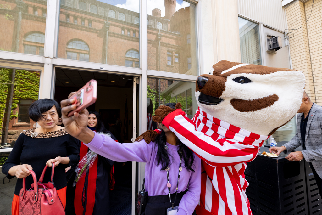 Pharmacy_Graduation_2024_162 A graduate poses with Bucky Badger