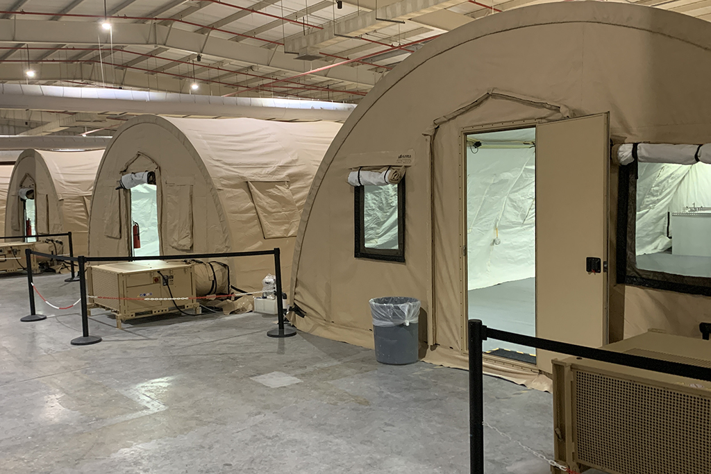 Tan-colored tents inside of an airplane hangar