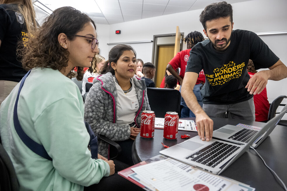 The Wonders of Pharmacy_032024_PLNZ72_7053 Third-year PharmD student Talha Mohammad chats with (l to r) Jana Alhuniti and Jiya Naik about the MEDSMART: Adventures in PharmaCity game during the Wonders of Pharmacy on Saturday, March 2, 2024, at the School of Pharmacy on the campus of UW-Madison. (Photo Paul L. Newby, II)