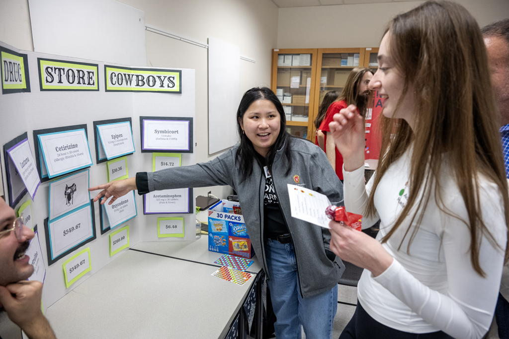The Wonders of Pharmacy_032024_PLNZ72_7190 First-year PharmD student Emily Lloyd reveals the correct answers after Ava Mueller tried her luck at The Drug Store Cowboys game during the Wonders of Pharmacy on Saturday, March 2, 2024, at the School of Pharmacy on the campus of UW-Madison. (Photo Paul L. Newby, II)