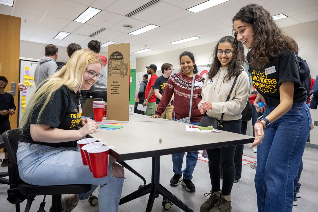 The Wonders of Pharmacy_032024_PLNZ72_7311 Kavya Kashyap keeps a close eye on the coin she spun alongside her mother, Lalitha Kashyap, as first-year PharmD student Nourhan El-Sanjak cheers her on as she plays the Pharmacy Pipeline activity during the Wonders of Pharmacy on Saturday, March 2, 2024, at the School of Pharmacy on the campus of UW-Madison. (Photo Paul L. Newby, II)