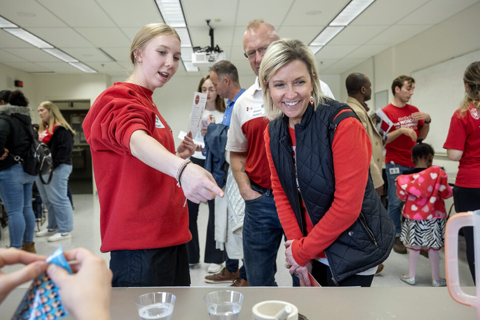 The Wonders of Pharmacy_032024_PLNZ72_7472 Brooke Siebert talks to her parents, Shawn and Jessie Siebert, about how The Gas Buster activity works during the Wonders of Pharmacy on Saturday, March 2, 2024, at the School of Pharmacy on the campus of UW-Madison. (Photo Paul L. Newby, II)