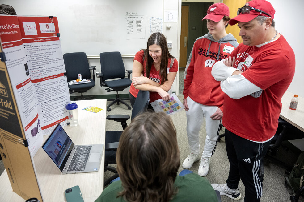 The Wonders of Pharmacy_032024_PLNZ72_7717 Aiden Karst, center, along with his parents, Ryan and Heather Karst, listen to PharmD student Lucas Kelisy explain the Operation Substance Use Discorder station during the Wonders of Pharmacy on Saturday, March 2, 2024, at the School of Pharmacy on the campus of UW-Madison. (Photo Paul L. Newby, II)
