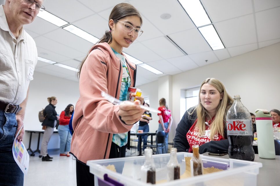 The Wonders of Pharmacy_032024_PLNZ72_7918 Claire Schnurr tries out the Interactions Have Consequences activity as her father, Russ Schnurr, looks on during the Wonders of Pharmacy on Saturday, March 2, 2024, at the School of Pharmacy on the campus of UW-Madison. (Photo Paul L. Newby, II)