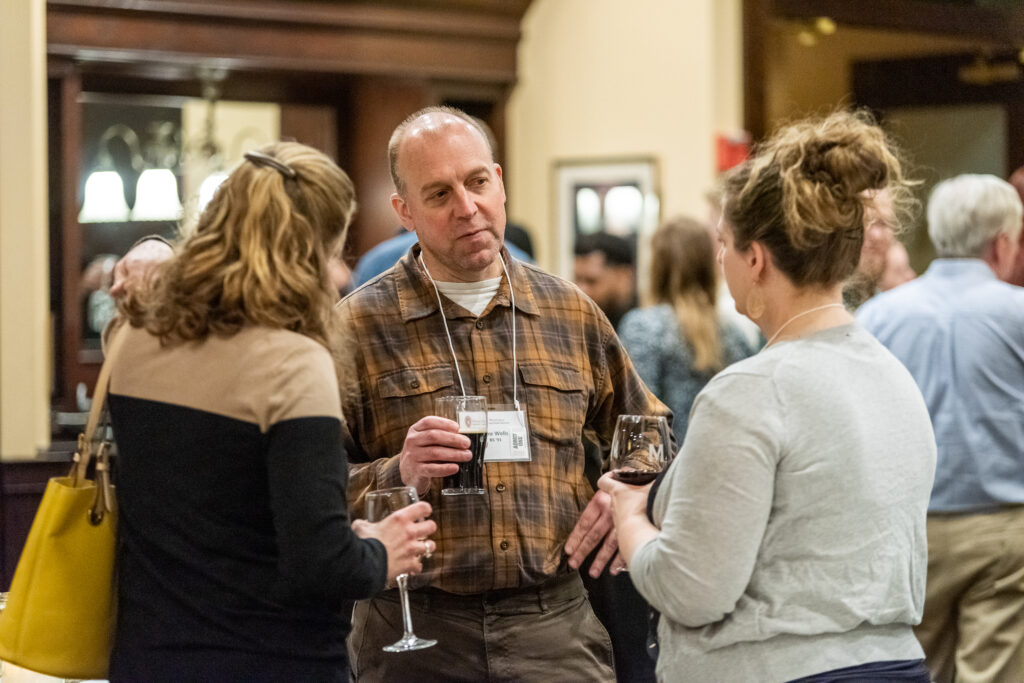 UW-Pharm-Maggianos_20220426_DSC_8400_001 Alumni holding drinks talking together