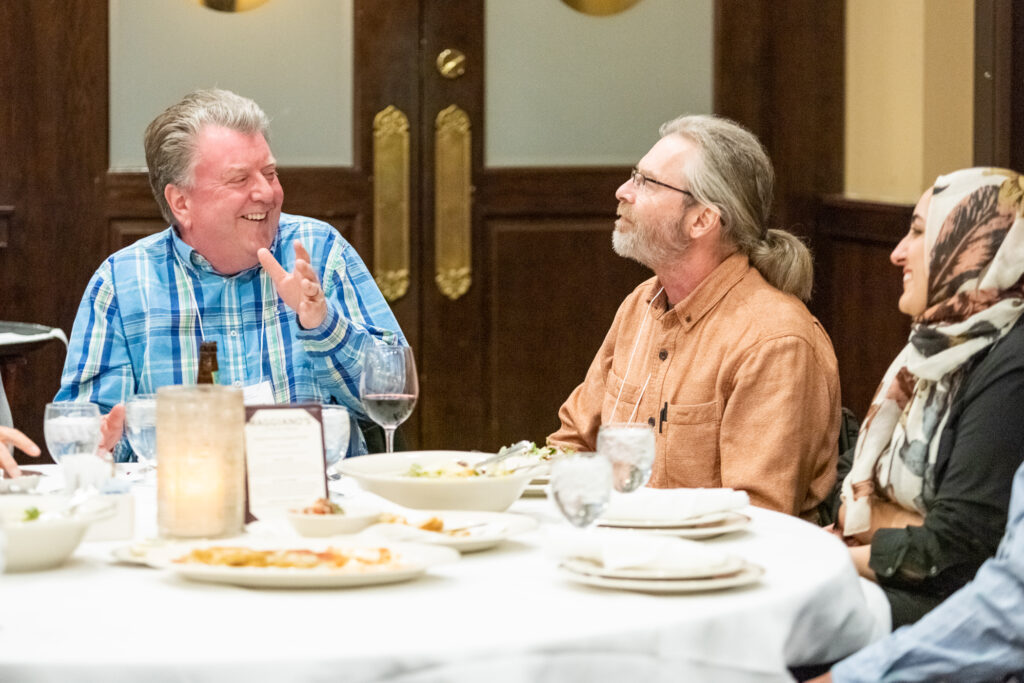 UW-Pharm-Maggianos_20220426_DSC_8468_015 Alumni speaking together around a table