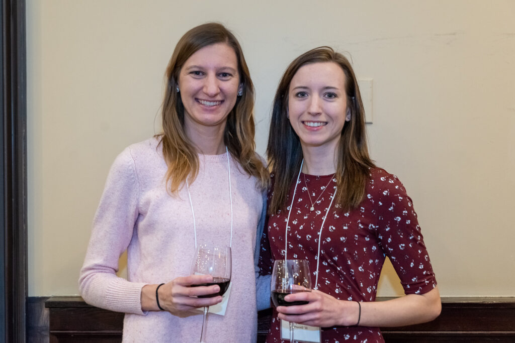 UW-Pharm-Maggianos_20220426__DSC2440_006 Two female alumni arm in arm with wine glasses