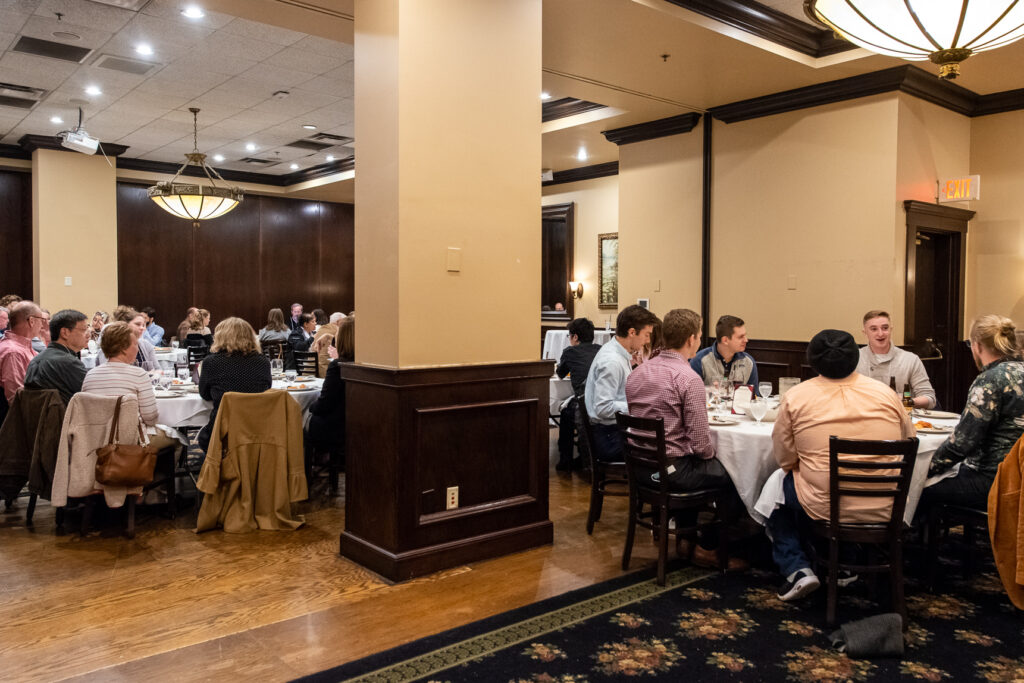 UW-Pharm-Maggianos_20220426__DSC2488_047 Pan out shot of tables filled with alumni for an event