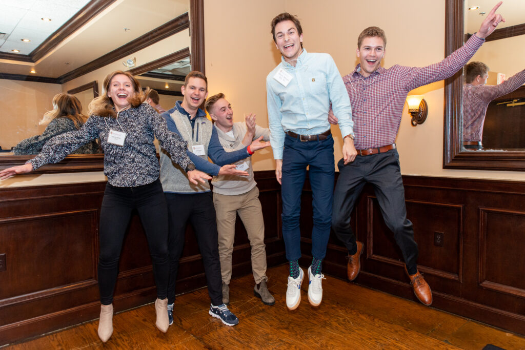 UW-Pharm-Maggianos_20220426__DSC2547_130 Alumni laughing and jumping mid-air