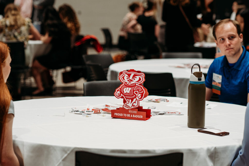 UWL-PAA-2 An alum seated at a table with a "Proud to be a Badger" centerpiece.