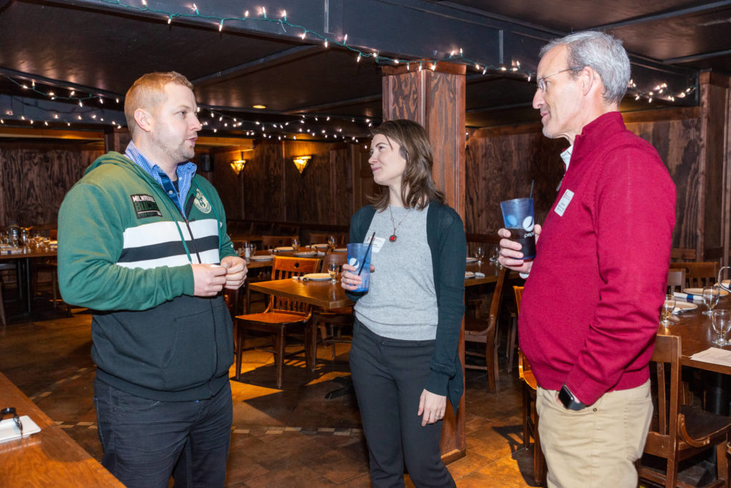 James Reynolds speaking Alissa Karnaky and David Mott with empty tables behind them