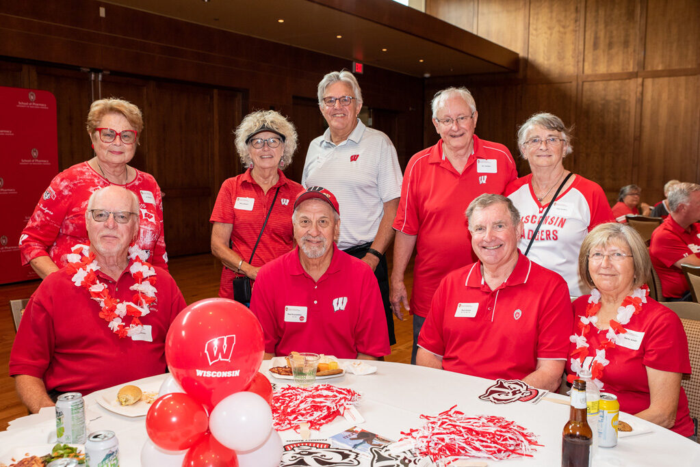 UWPharm-Tailgate_09172022_001 A group of alumni, including Russ and Sandra Jensen, Terry and Mary Maves, Jim and Char Sanders, and Paul Pisaroewicz smile and pose for the photo.