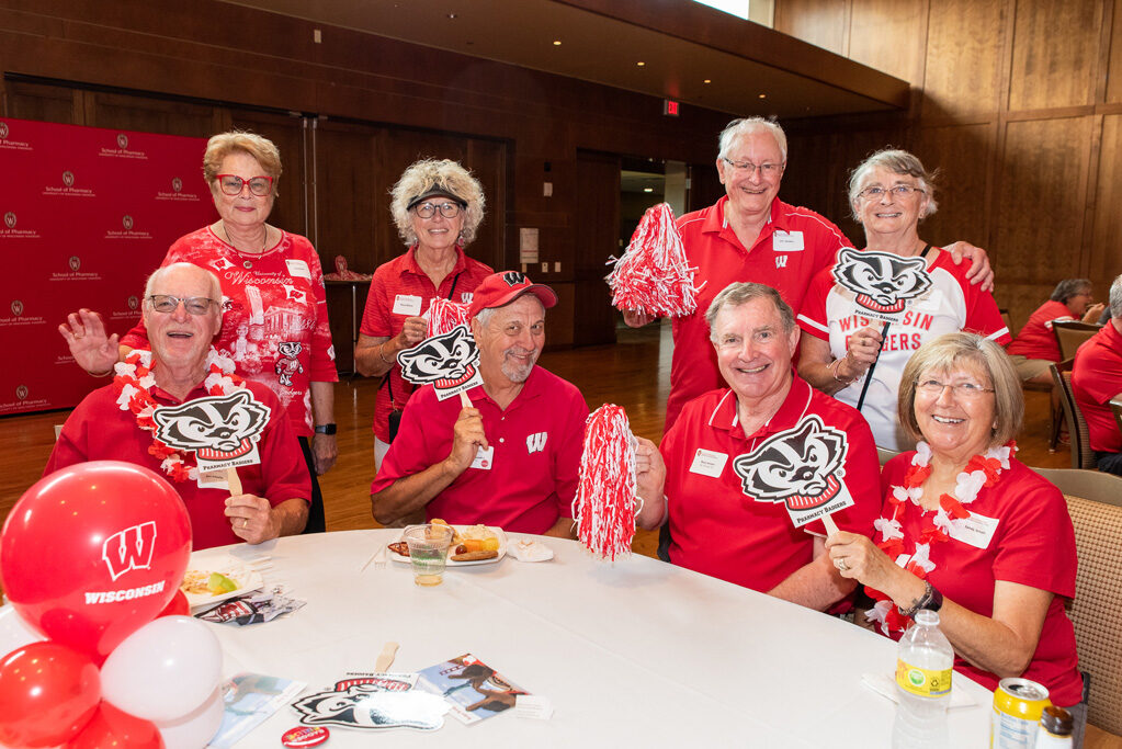 UWPharm-Tailgate_09172022_002 A group of alumni, including Russ and Sandra Jensen, Terry and Mary Maves, Jim and Char Sanders, and Paul Pisaroewicz smile and pose for the photo.