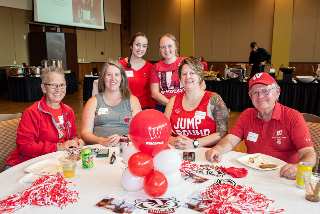 UWPharm-Tailgate_09172022_003 A group of alumni, including Patti, Steve, Mary, and Elizabeth Thornewell, smile and pose with Bucky gear.