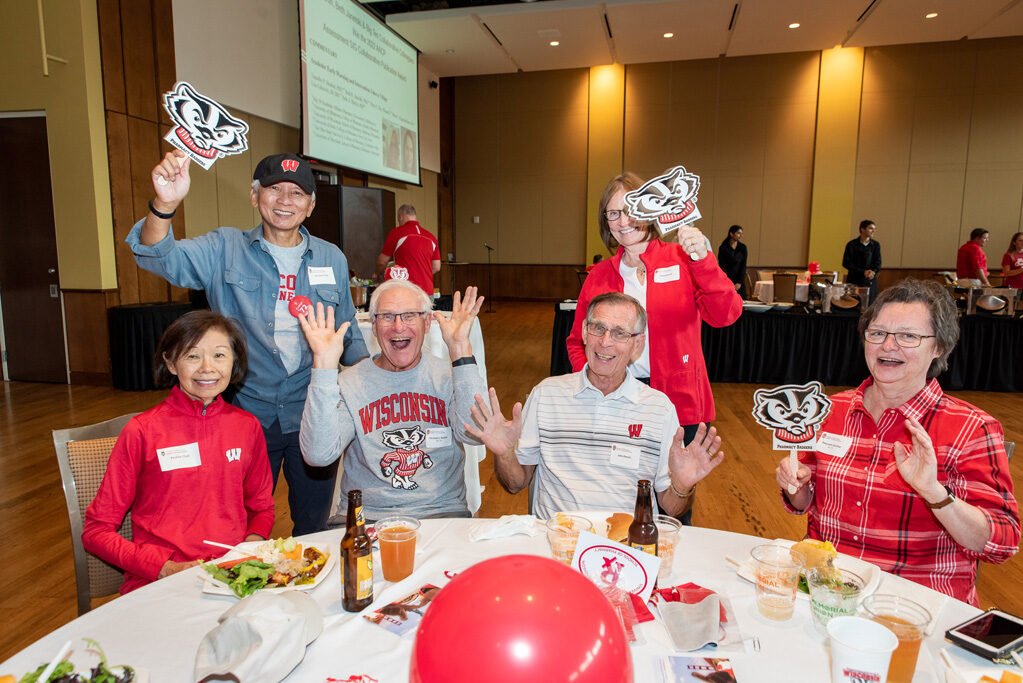 UWPharm-Tailgate_09172022_006 A group of alumni smile and pose with Bucky gear.