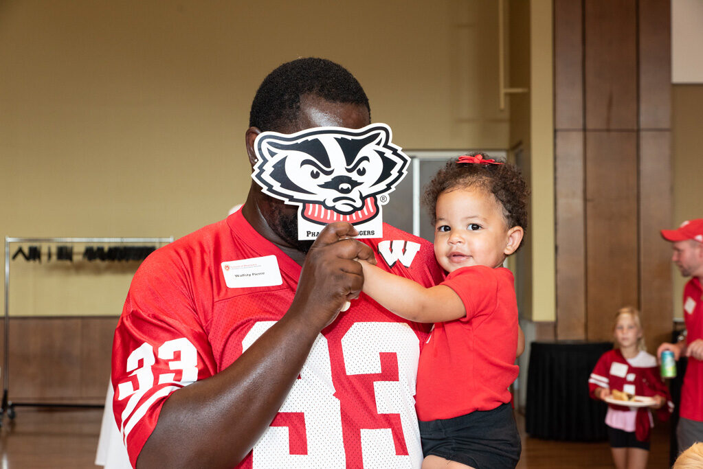 UWPharm-Tailgate_09172022_008 Walfsty Pierre and a young toddler pose with a Bucky on a stick.