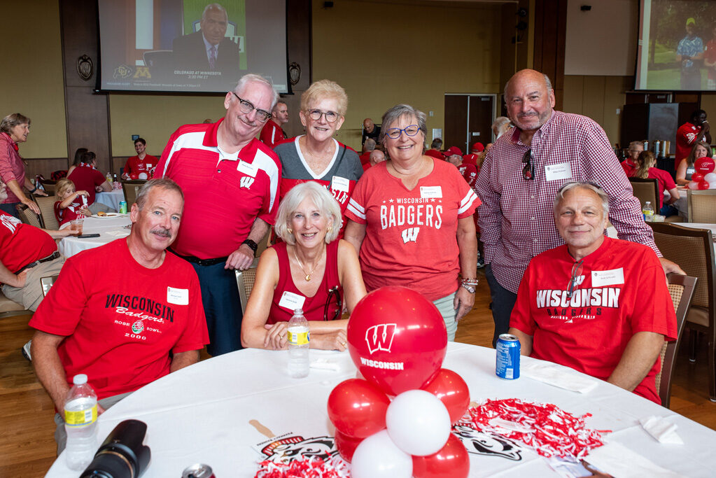 UWPharm-Tailgate_09172022_018 A group of alumni smile and pose with Badger gear.