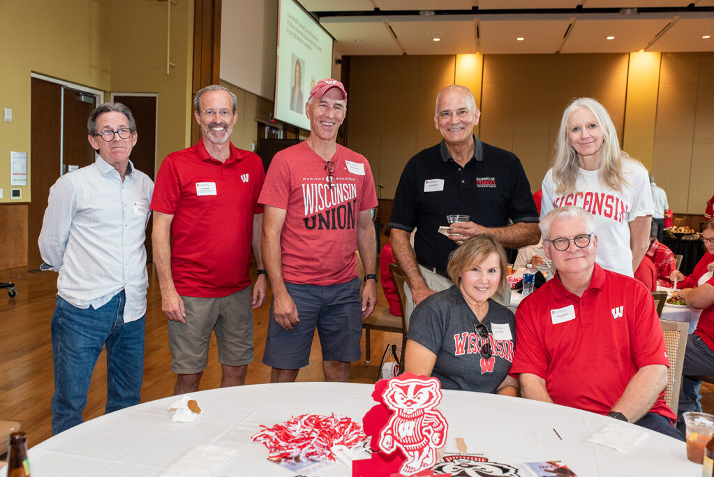 UWPharm-Tailgate_09172022_022 A group of alumni, including John Swann, Rick Bertz, and others, smile at the camera with Professor Paul Hutson and Associate Dean for Advancement Dave Mott.